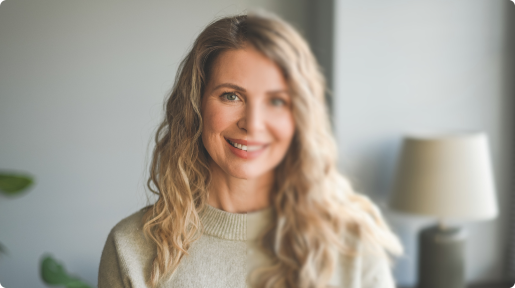 Smiling woman portrait with a split effect, left side sharp and right side blurred to show clear vs blurry vision.