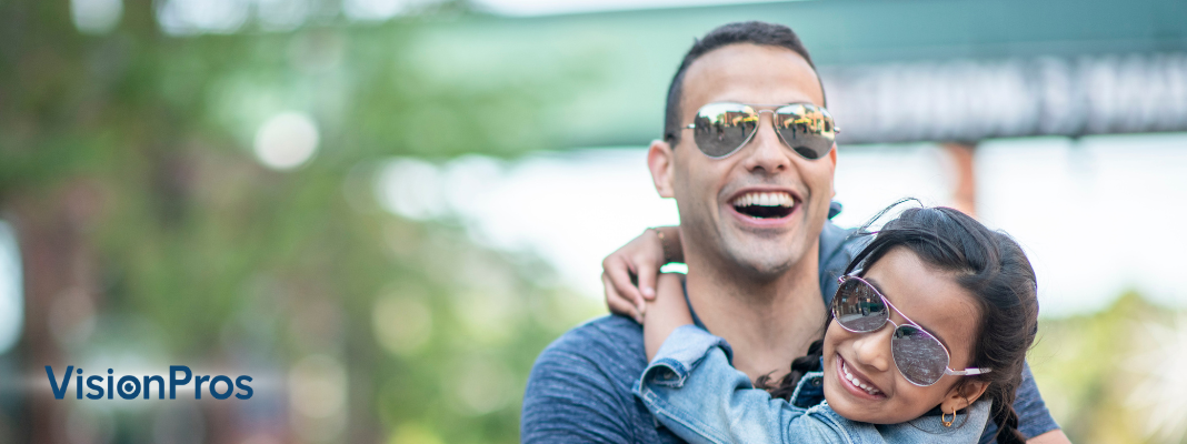 Alt text: Smiling father and daughter wearing sunglasses outdoors for a Father’s Day sunglasses gift guide by VisionPros.